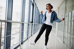 African woman in jeans jacket posed indoor. photo