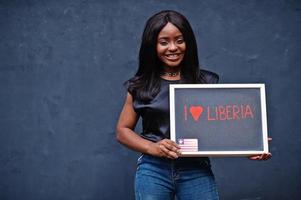 I love Liberia. Fashionable african woman hold chalkboard with liberian flag. photo