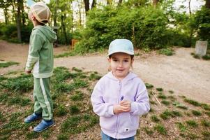 Sister with brother walking in forest. photo