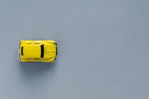 plano en un moderno 2021 nuevos colores. amarillo iluminador y gris definitivo. color del año 2021. coche de juguete retro sobre fondo gris con espacio de copia foto