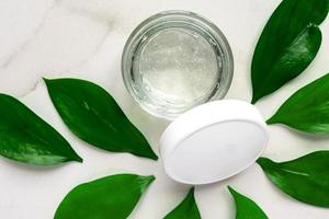 Natural moisturising cream gel jar on green leaves as beauty flatlay, spa cosmetics and skincare closeup photo