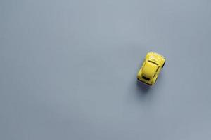 plano en un moderno 2021 nuevos colores. amarillo iluminador y gris definitivo. color del año 2021. coche de juguete retro sobre fondo gris con espacio de copia foto