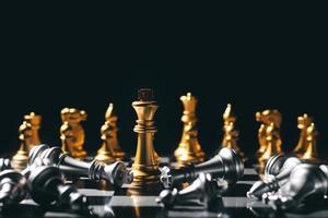 primer plano rey de pie sobre un tablero de ajedrez. hay un ajedrez cayendo al frente, liderazgo. desafíos del equipo de negocios de trabajo en equipo, ganadores de la industria global.