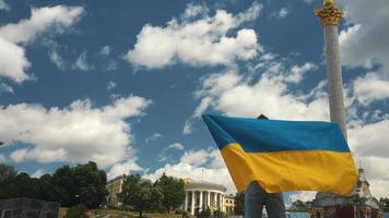 junge frau hält und winkt flagge der ukraine in der innenstadt von kiew video
