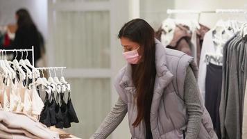 Young woman wearing face mask browses socks at a clothing store video