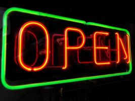 open neon sign in shop window at night photo