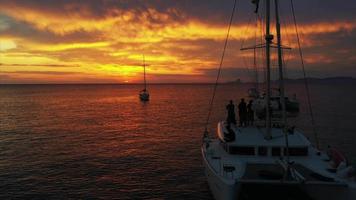 Fliegen Sie über den Meerblick von Yachten in orangefarbenem und gelbem Sonnenuntergangslicht video