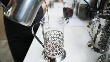 de l'eau chaude est versée dans une presse en verre pour infuser le thé video