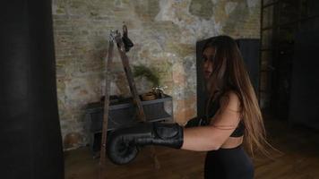 långsam rörelse av kvinna slå stansning väska med boxning handskar video