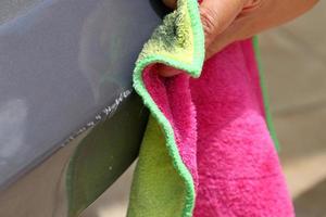 car scratches and hands are scrubbing with a cloth. photo