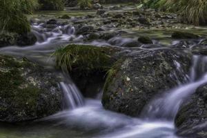 Flowing mountain stream with stones photo