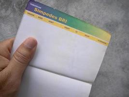 Sidoarjo, Jawa timur, Indonesia, 2022 - a man holding a bri simpedes bank passbook open photo