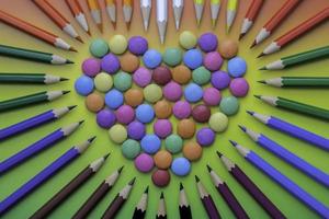 Multicolored heart shaped candies and  colored crayons photo