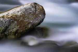 Big stone in mountain flowing stream photo