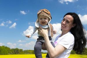 Baby pilot, in a pilot's hat, helmet, on the hands of a young, beautiful brunette girl. copy space. photo