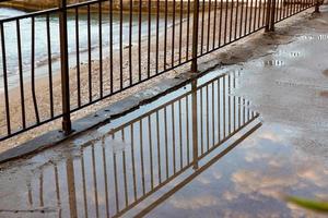 reflection of metal fence on the water after raining day photo