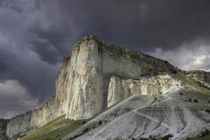 Mountainous, rocky landscape and White Rock peak against a stormy sky. photo