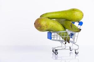 peras de conferencia verde en un carrito de compras, sobre un fondo blanco. copie el espacio foto