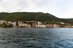 montenegro, hermosos pueblos marinos, casas residenciales junto al mar, vista desde el agua. foto