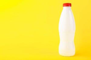 White plastic bottle for milk on a yellow background. Copy space. photo