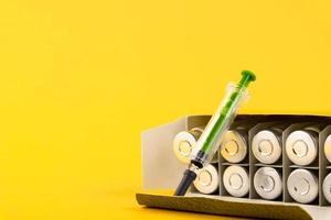 Bubbles, ampoules with dry probiotic, bifidobacteria, on a yellow background. Copy space. photo