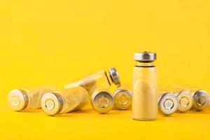 Bubbles, ampoules with dry probiotic, bifidobacteria, with probiotic powder inside on a yellow background. Copy space. photo