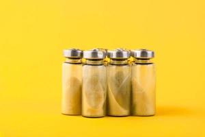 Bubbles, ampoules with dry probiotic, bifidobacteria, on a yellow background. Copy space. photo