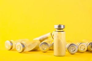 Bubbles, ampoules with dry probiotic, bifidobacteria, with probiotic powder inside on a yellow background. Copy space. photo