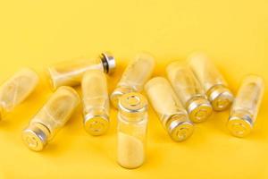 Bubbles, ampoules with dry probiotic, bifidobacteria, with probiotic powder inside on a yellow background. Copy space. photo