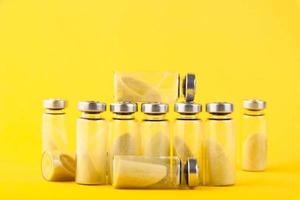 Bubbles, ampoules with dry probiotic, bifidobacteria, with probiotic powder inside on a yellow background. Copy space. photo