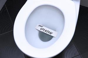 The words, the phrase, YOUR OPINION is written on the note card and floats in the toilet bowl as a reminder of the importance of customer feedback. photo