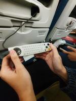 The interior of the passenger seat of a Turkish Airlines plane that has a touch screen for in-flight entertainment. Which is also equipped with a remote controller that also functions as a game stick photo