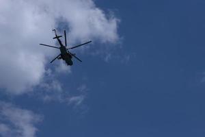 Military Russian helicopter flies in the sky. Bottom view. photo