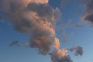 paisaje de nubes. nubes de cúmulos de verano rosas y marrones en un cielo azul durante la puesta de sol. fondo de pantalla. antecedentes. foto