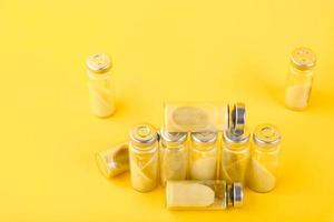 Bubbles, ampoules with dry probiotic, bifidobacteria, with probiotic powder inside on a yellow background. Copy space. photo