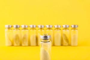 Bubbles, ampoules with dry probiotic, bifidobacteria, with probiotic powder inside on a yellow background. Copy space. photo