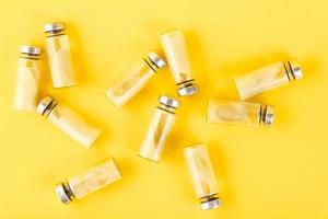 Bubbles, ampoules with dry probiotic, bifidobacteria, with probiotic powder inside on a yellow background. Copy space. photo