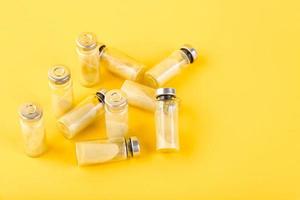 Bubbles, ampoules with dry probiotic, bifidobacteria, with probiotic powder inside on a yellow background. Copy space. photo