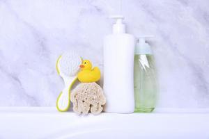 Children's hygiene products concept. Yellow duckling in the bathroom on a background of gray tiles. Copy space photo