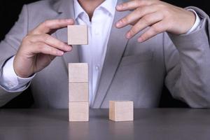 A businessman builds a pyramid of wooden cubes to write a five-letter word. Copy space photo