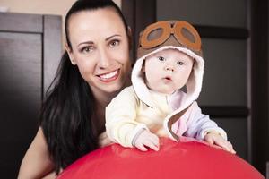 Aviator kid, in a pilot hat, together with a beautiful young mother, close up portrait. photo