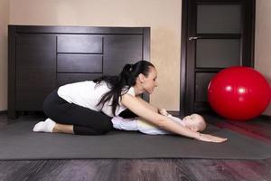 The child plays, does exercises, does gymnastics with his mother at home. photo