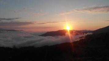 espectacular lapso de tiempo de puesta de sol sobre las nubes en la región de adjara con paso de nubes y sol sobre el horizonte. Impresionante fondo de puesta de sol vibrante sobre las nubes video