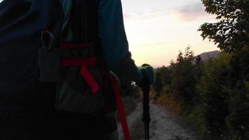 escursionista zaino in spalla su foresta pista godere drammatico tramonto al di sopra di nuvole nel a distanza Caucaso montagne caldo estate sera video