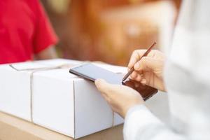delivery service courier ringing the house doorbell with boxes in hands photo