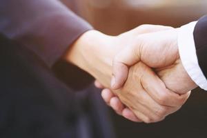 Close Up of a businessman young handsome hand shake between two colleagues.or Negotiated agreement successful job. photo