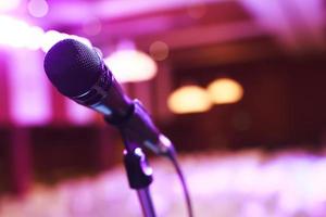 Close up of microphone on stage lighting at concert hall or conference room. copy space banner. soft focus. photo