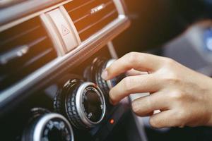 Closeup of hand driver man checking switch adjusting air from conditioning the cooling system with flow of cold in car. Leave space for writing text. photo