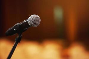 Close up of microphone on stage lighting at concert hall or conference room. copy space banner. soft focus. photo