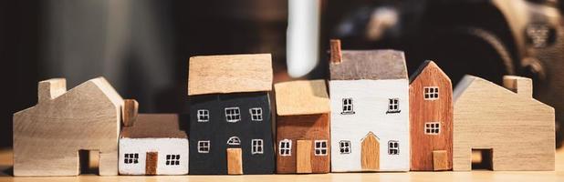 casa en modelo de papel reciclado marrón sobre mesa de madera en el fondo del jardín. casa ecológica. foto